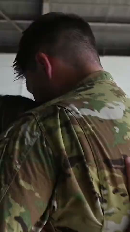 A service member embracing their family